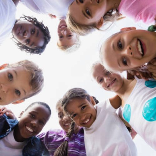 Kids posing together during a sunny day at camera at park